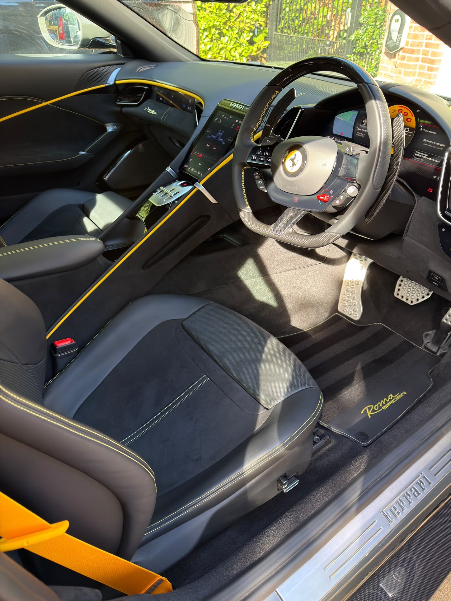 Deep-cleaned Ferrari Roma Spider interior with black leather, yellow stitching and vacuum-striped carpets